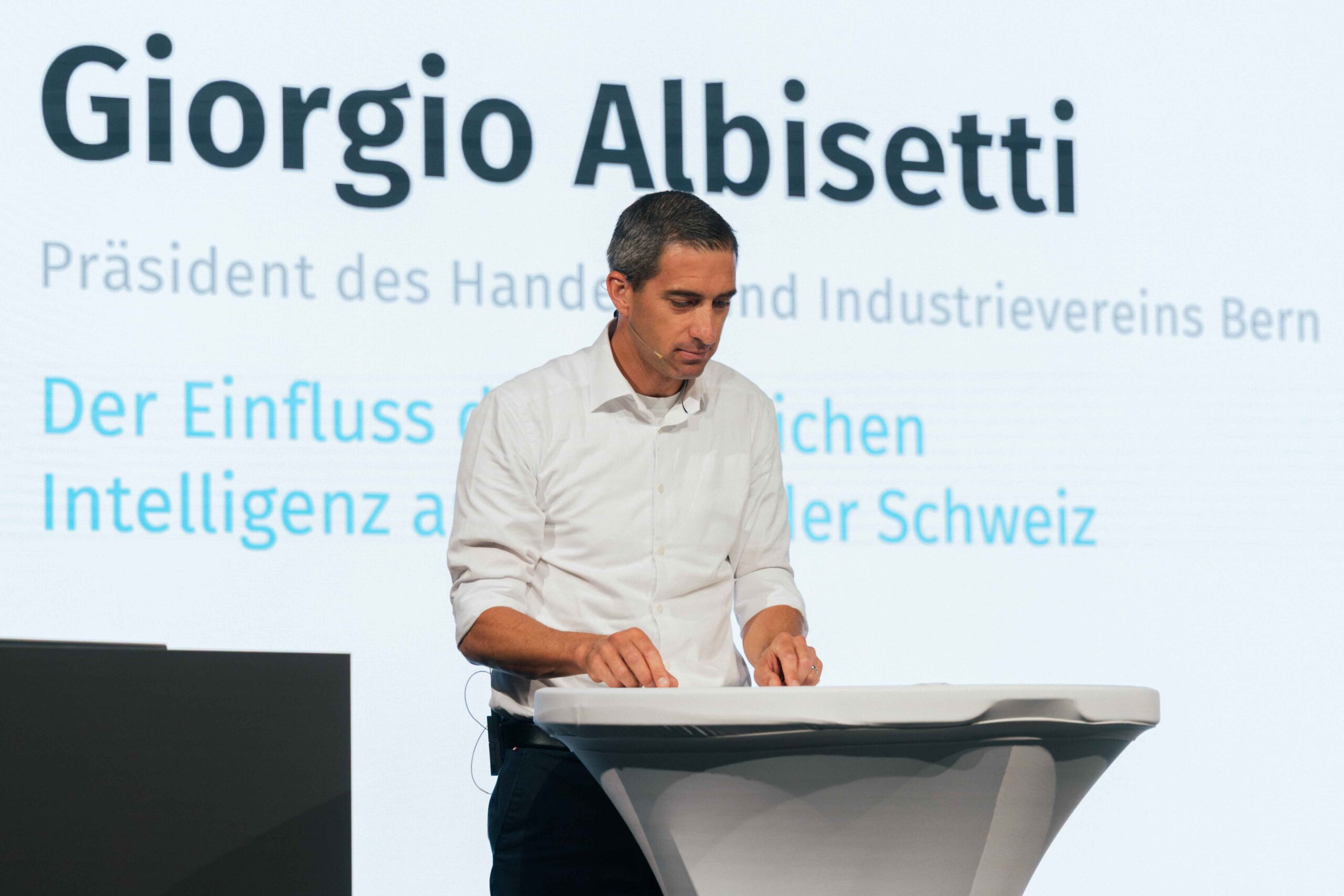 Giorgio Albisetti hält einen Vortrag vor einem Publikum mit einem LED Screen im Hintergrund